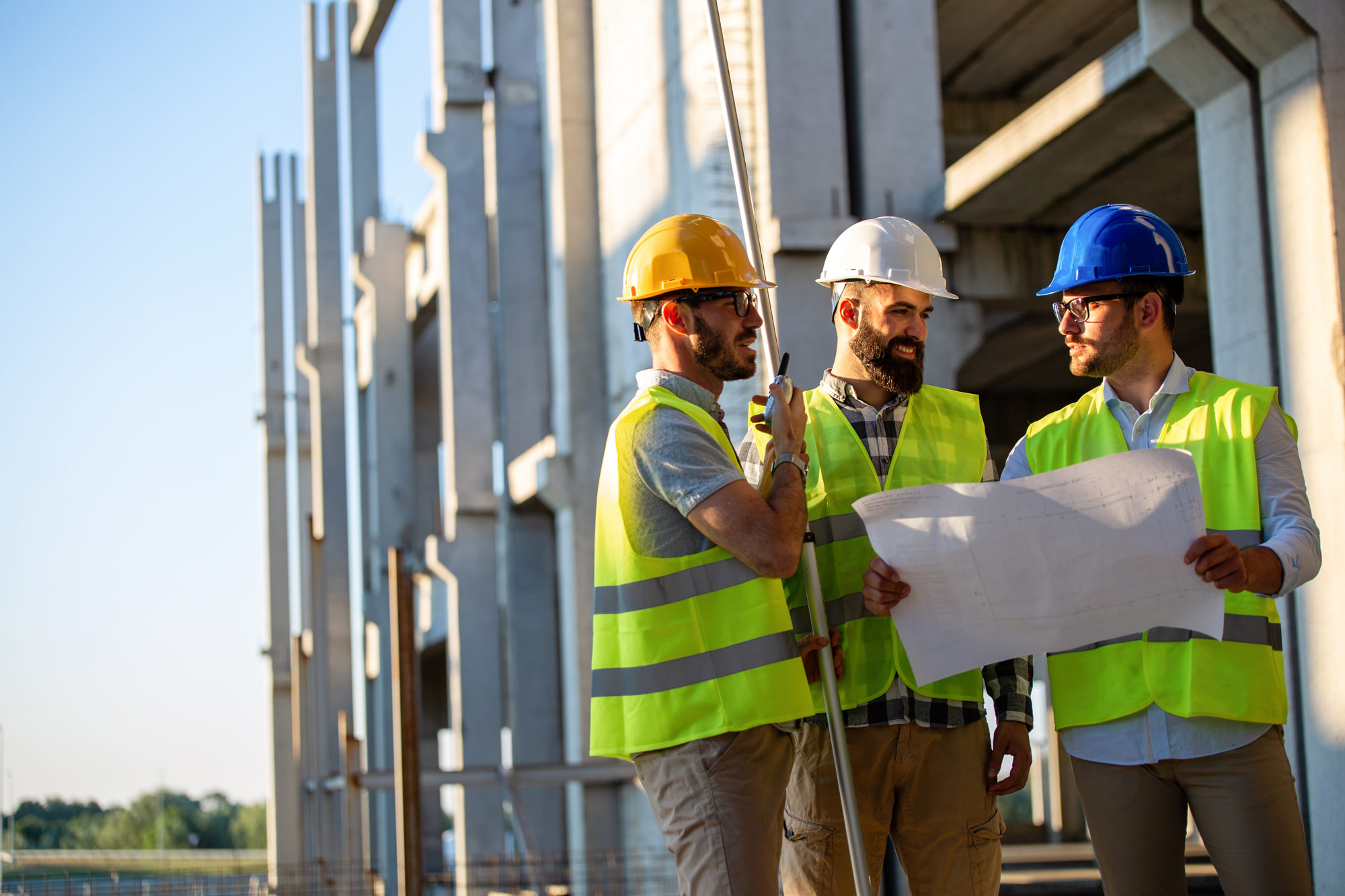 Group of construction worker talking with a radio in hand