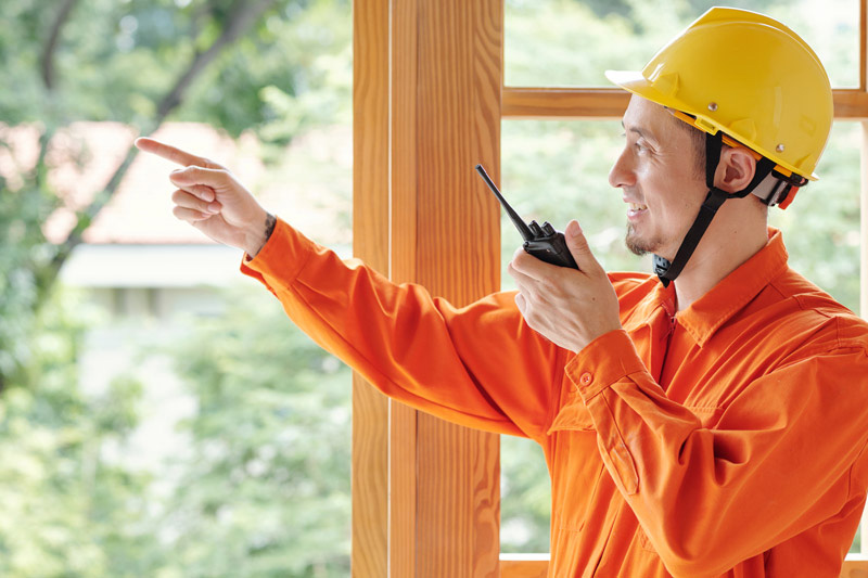 A man holding the two way radio on the construction site